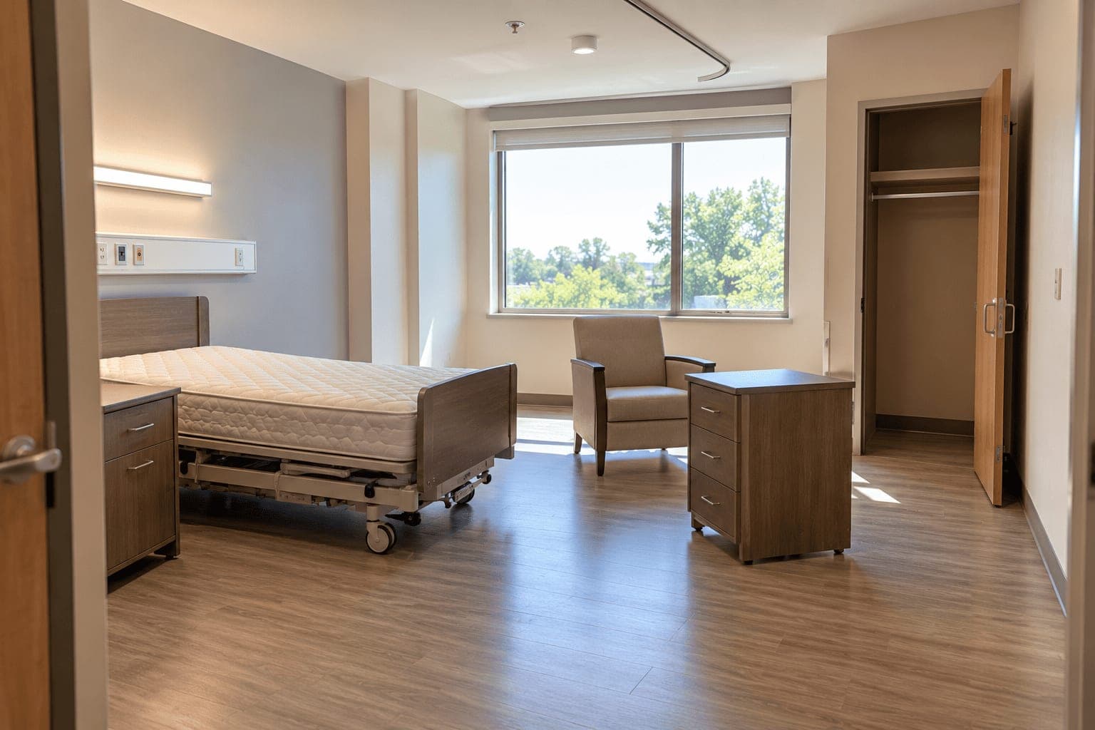 A resident room mid turnover: the bed stripped to the mattress, the furniture pulled away from the wall and the closet empty.